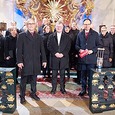 v.l.n.r.  Pfarrgemeindebegleiter Karl Ramsmaier, Bischof Scheuer, Moderator Günther Madlberger Im Hintergrund der Chor „Camerata Garstina“ unter der Leitung von Klaus Oberleitner.